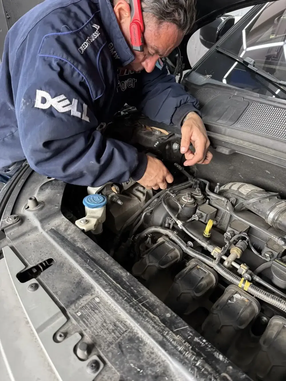 Favio close-up working on the Land Rover AC service port valve stem at Beacon Auto Care San Mateo