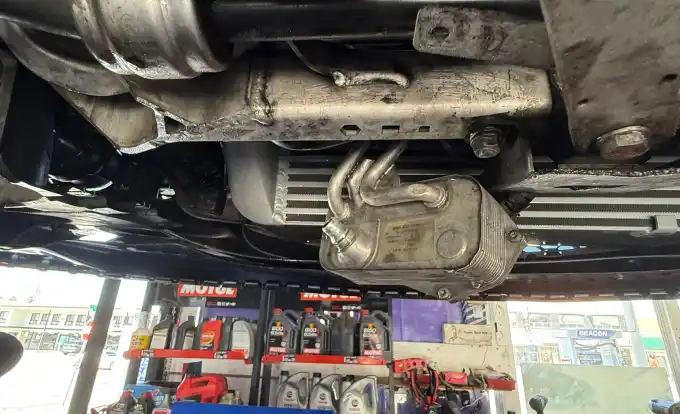 Transmission oil cooler inspected from underneath a vehicle at Beacon Auto Care San Mateo